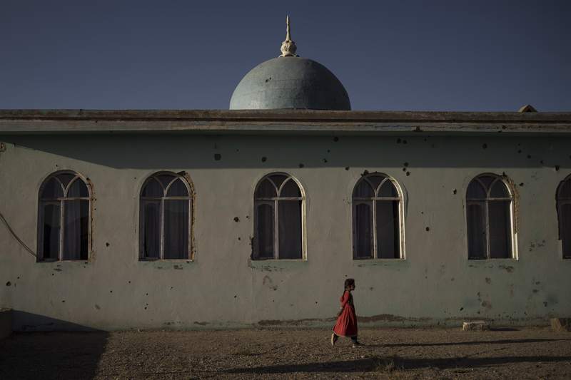 An Afghan miss  walks extracurricular  a mosque marked by slug  holes astatine  a colony   successful  Wardak province, Afghanistan, Monday, Oct. 11, 2021. (AP Photo/Felipe Dana)