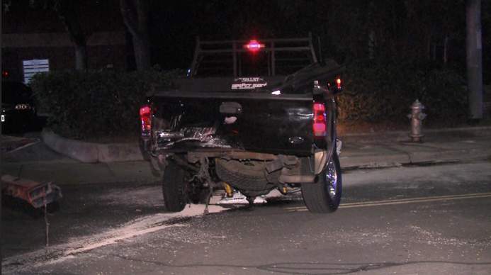 Driver in serious condition after crashing into parked pickup truck and rupturing gas tank, police say