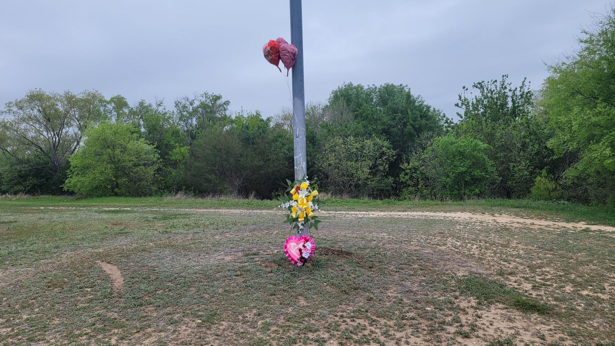 Balloons and flowers now hang from a pole near the ditch where the bodies of Savannah Kriger, 32, and her three-year-old son, Kaiden, were found Tuesday morning.