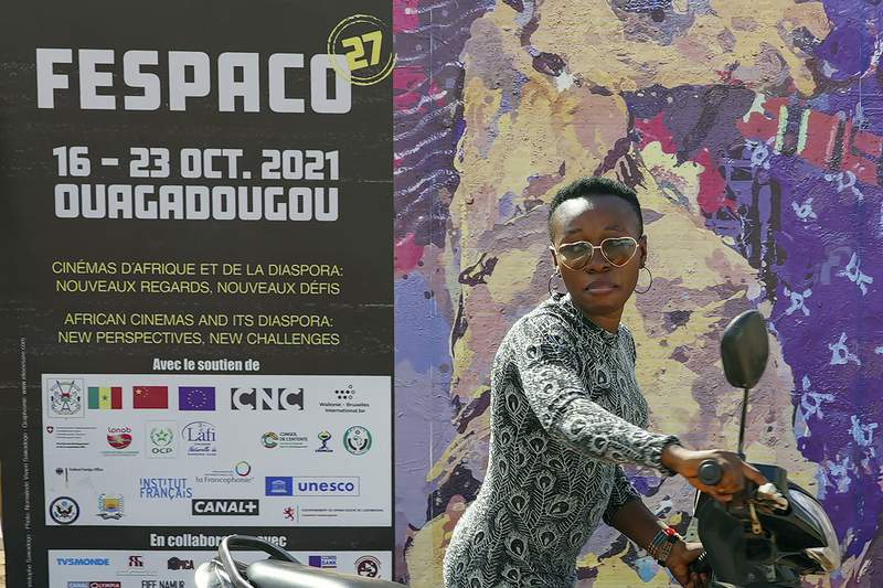 A pistillate   pushes her scooter past   the entranceway  of FESPACO (Pan-African Film & TV Festival of Ouagadougou) successful  Ouagadougou, Burkina Faso, Friday Oct. 15, 2021. The event, present  successful  its 52nd year, is attracting filmmakers and moviegoers from crossed  the continent and the globe. (AP Photo/Sam Mednick)