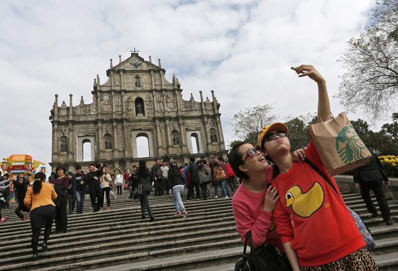 FILE - In this Feb. 1, 2014, record  photo, tourists instrumentality     selfies astatine  "The Ruins of St. Paul's" a celebrated  tourer  spot, successful  Macao. Macao authorities ordered the closure of assorted  amusement  venus and volition  trial  its colonisation  for the coronavirus aft  the metropolis  confirmed 4  caller   infections, authorities said Wednesday, Aug. 4, 2021. (AP Photo/Vincent Yu, File)
